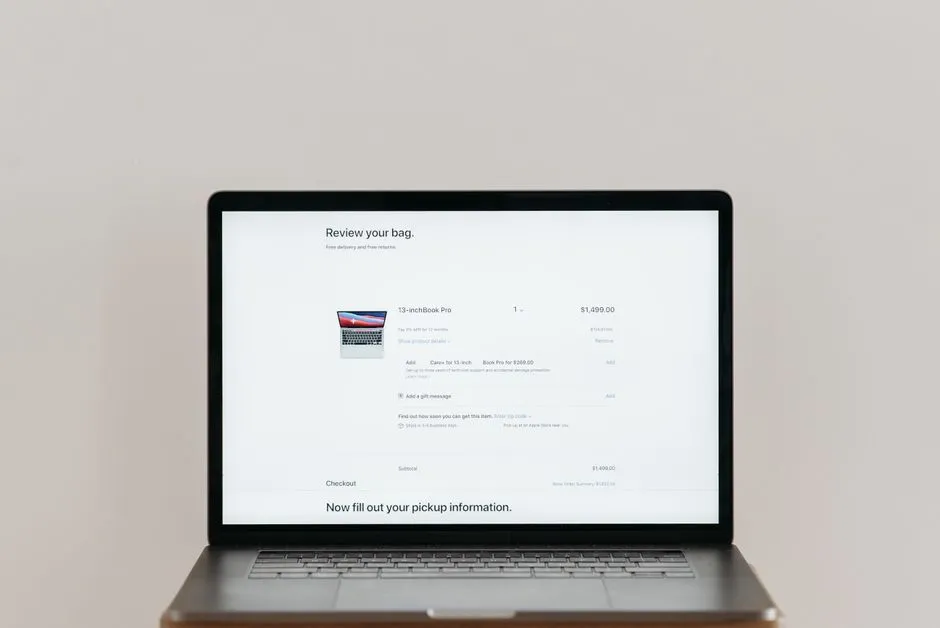 Minimalist laptop showing an online checkout screen on a white background, ideal for tech context.